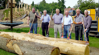 Arbeitsgruppe unterstützt Errichtung Mehrgenerationenspielplatz mit Bäume schälen